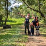 asian family of 5, with 3 young kids trekking in forest singapore